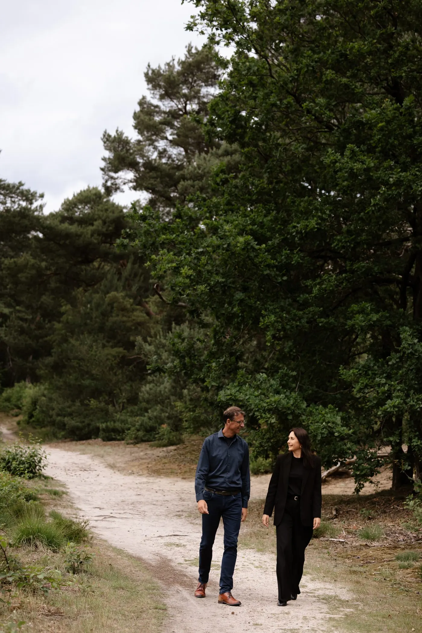 Sharon Beudeker en Jos Groen wandelen samen over een zandpad